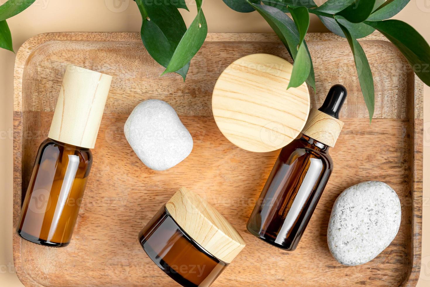 ensemble de cosmétiques naturels pour le visage et le corps. compte-gouttes en verre foncé sans marque avec des pots de sérum et de crème dans une atmosphère de style de vie confortable. tendance écologique naturelle. photo