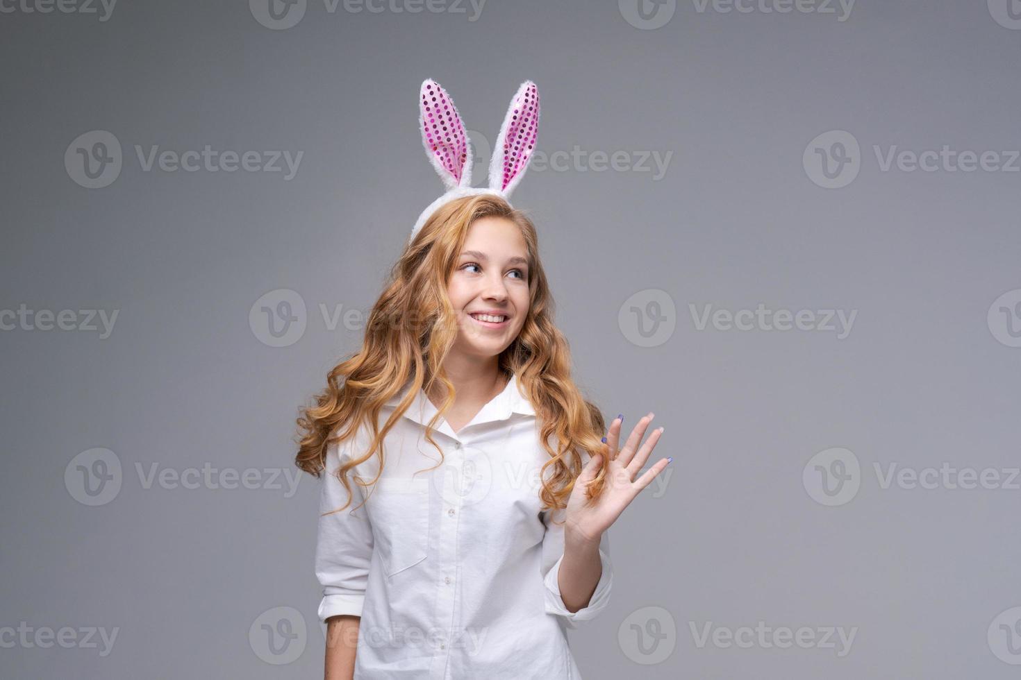 jeune belle femme dans de jolies oreilles de lapin de pâques fait un geste normal, joue photo