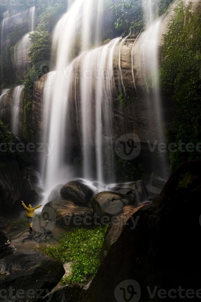 cascade tad wimanthip avec de beaux rochers et des touristes en imperméables admirent la beauté de la cascade. photo