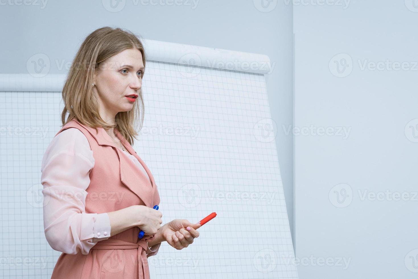 femme d'affaires avec un marqueur à la main donne une conférence photo