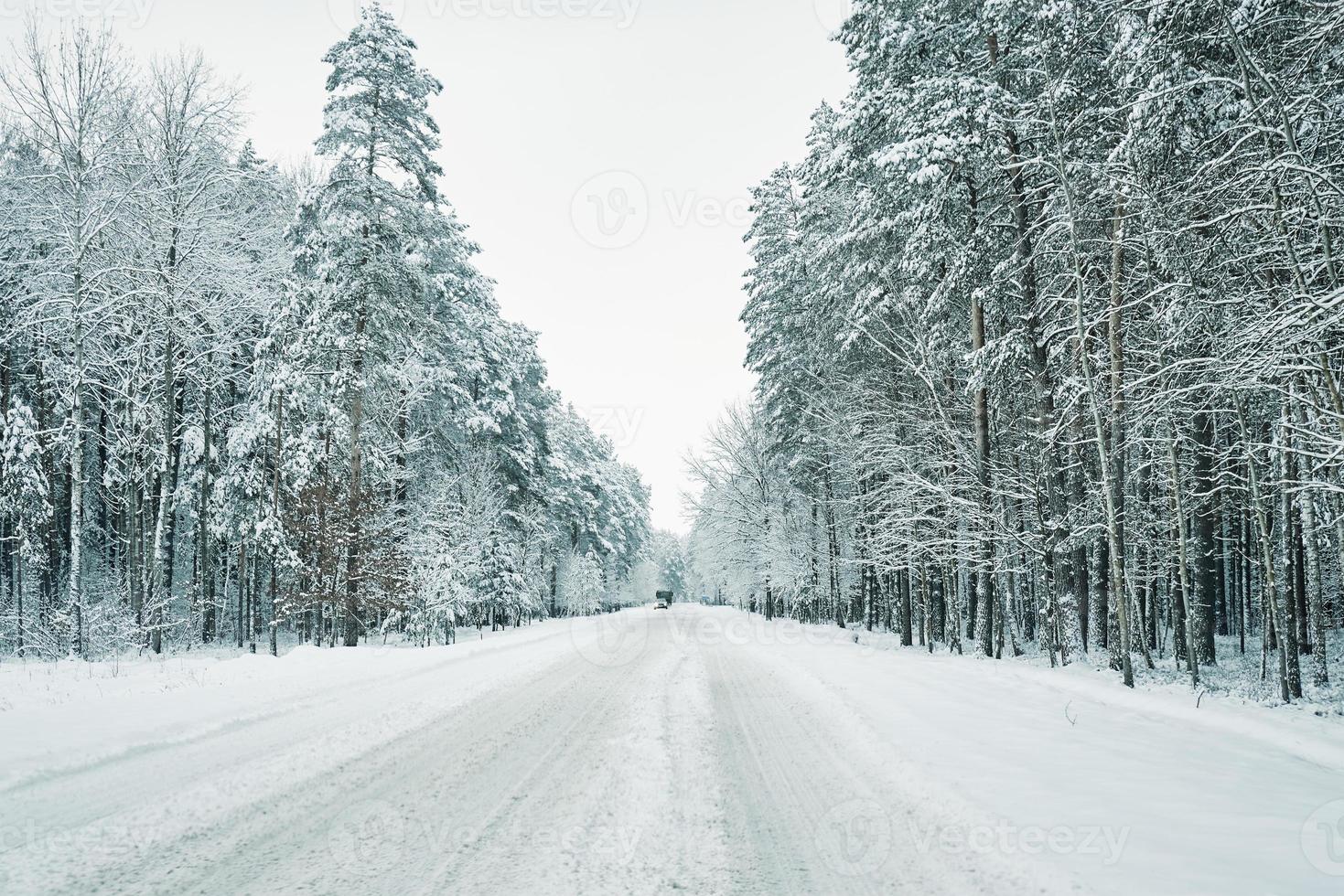 route enneigée dans la forêt d'hiver avec voiture en mouvement photo