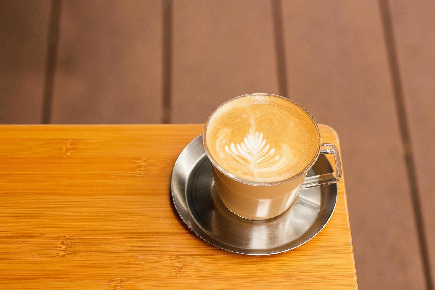 mousse d'art café latte chaud sur table en bois. photo