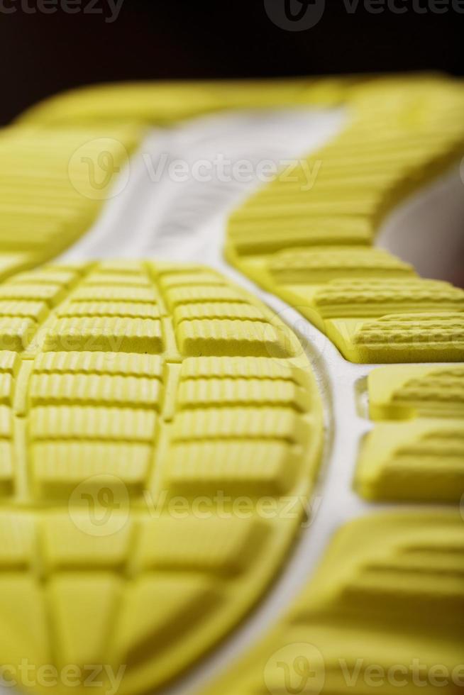 gros plan de la bande de roulement d'une sneaker jaune, le motif texturé de la semelle. photo