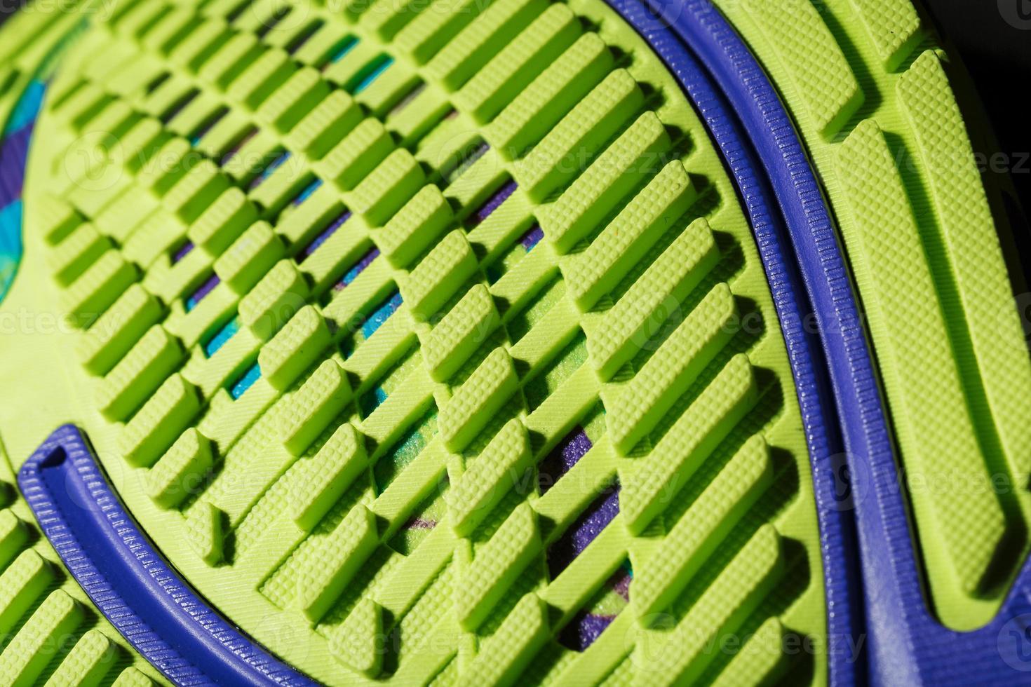 une chaussure de course sportive avec une semelle verte texturée sur fond noir. photo