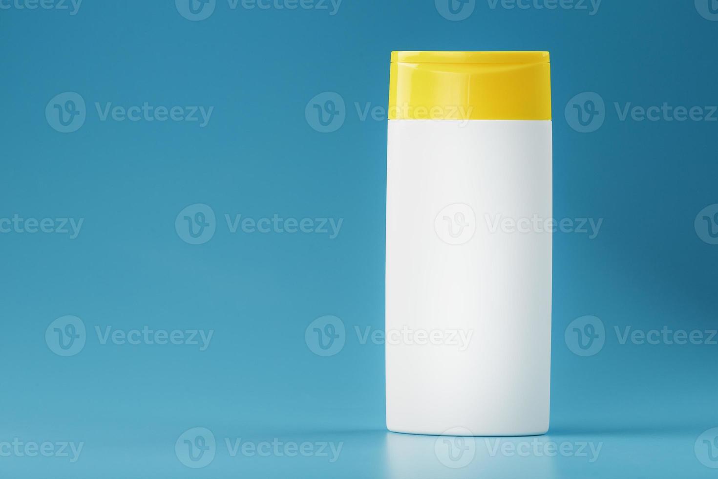 une bouteille blanche de shampoing et de gel douche avec un couvercle jaune. photo