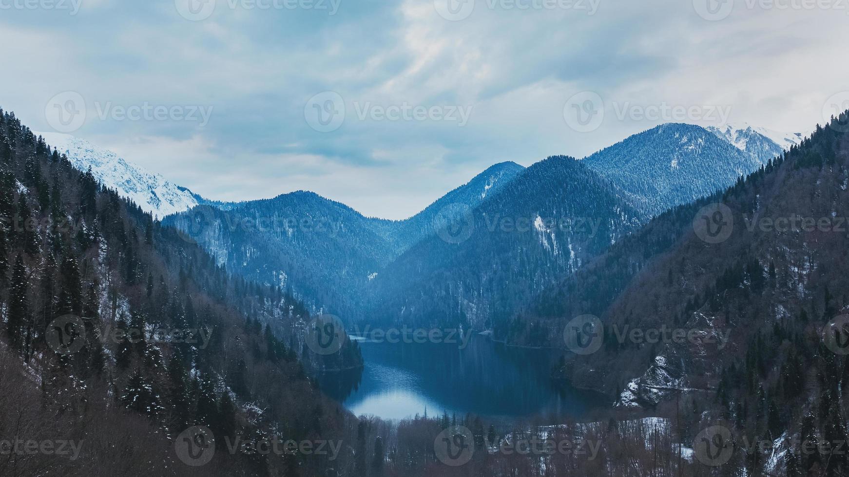 lac d'hiver ritsa en abkhazie avec des montagnes dans la neige en arrière-plan, tard dans la soirée. photo