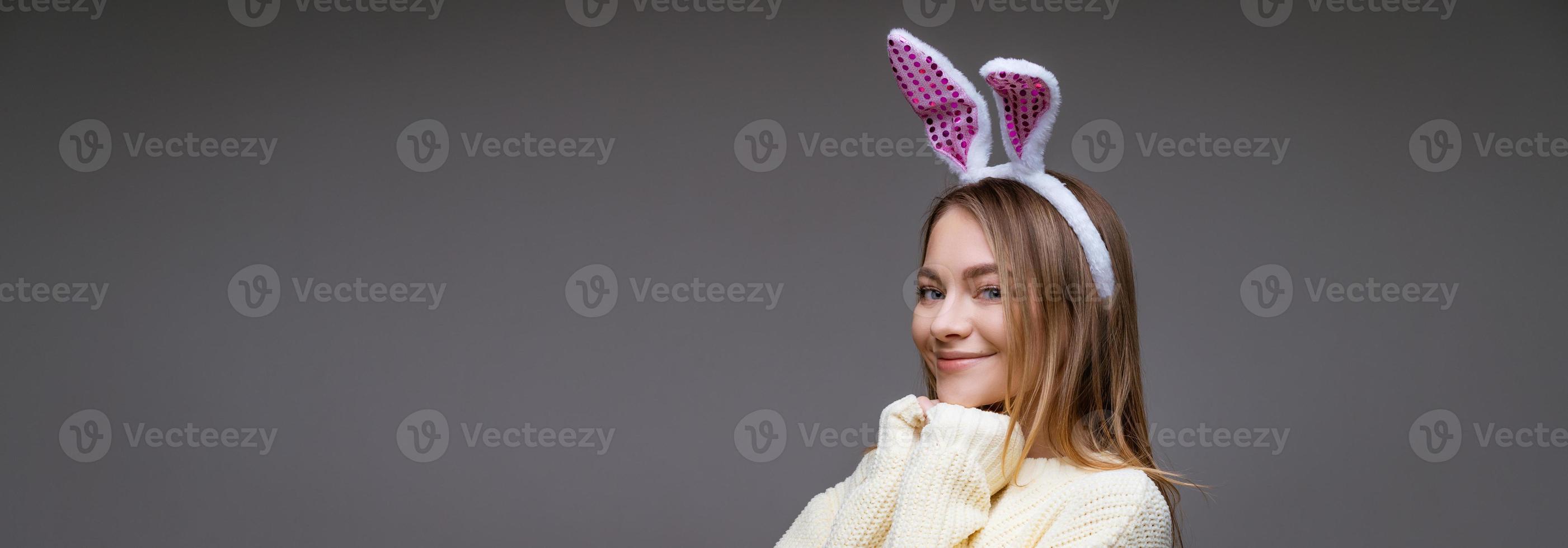 jeune femme en oreilles de lapin sur fond gris photo