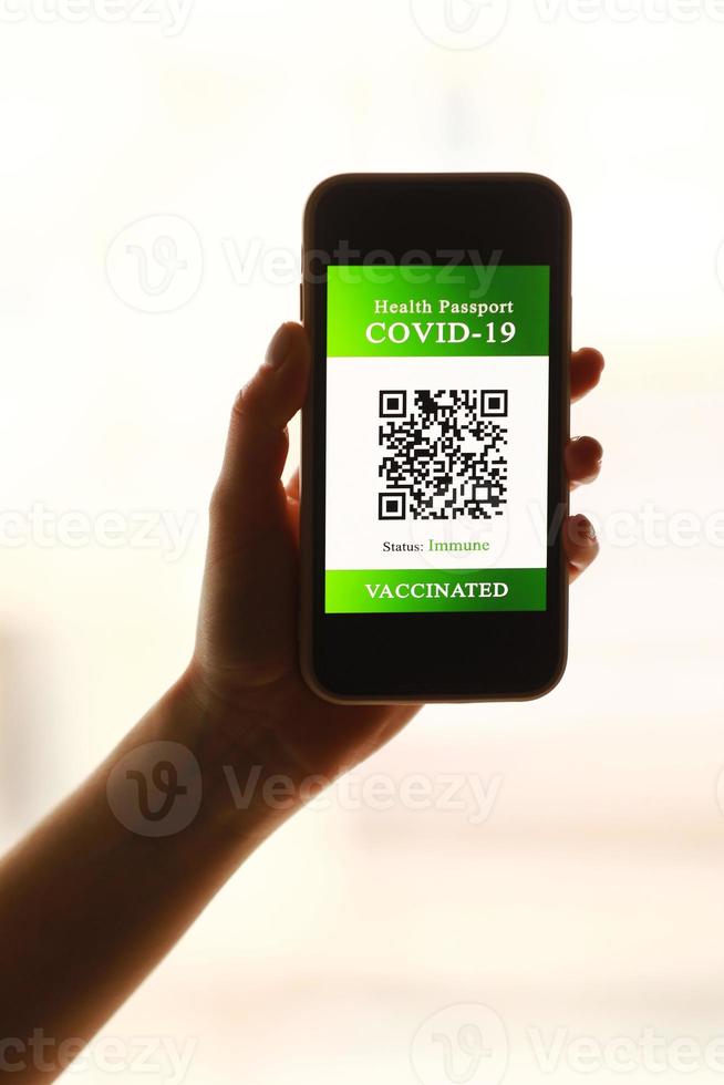 un passeport et un smartphone avec un certificat de vaccination contre la maladie covid-19. se concentrer sur le téléphone intelligent. concept de passeport de santé. Voyager à travers le monde photo