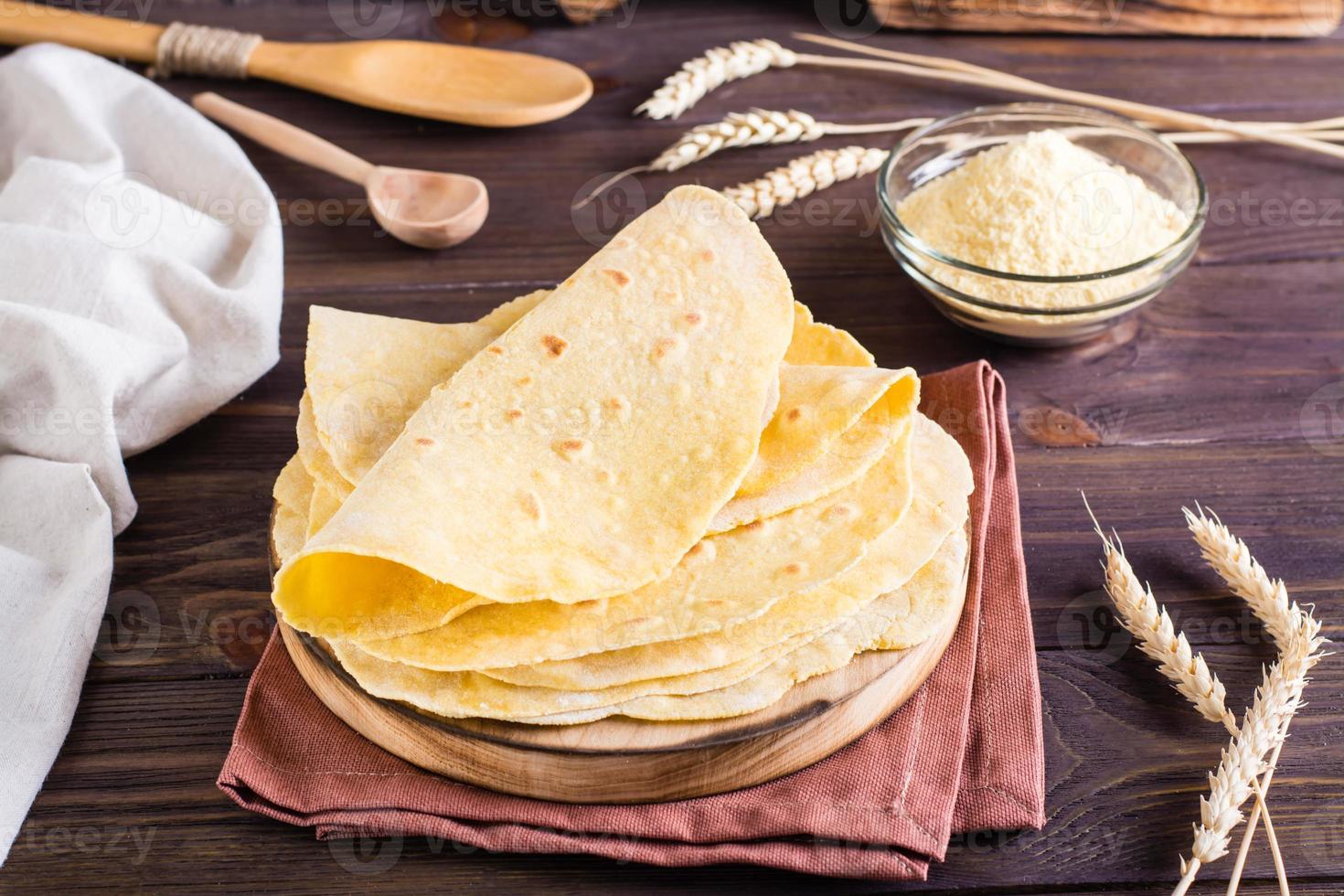 Des tortillas mexicaines de maïs faites maison s'enroulent sur une planche sur la table photo