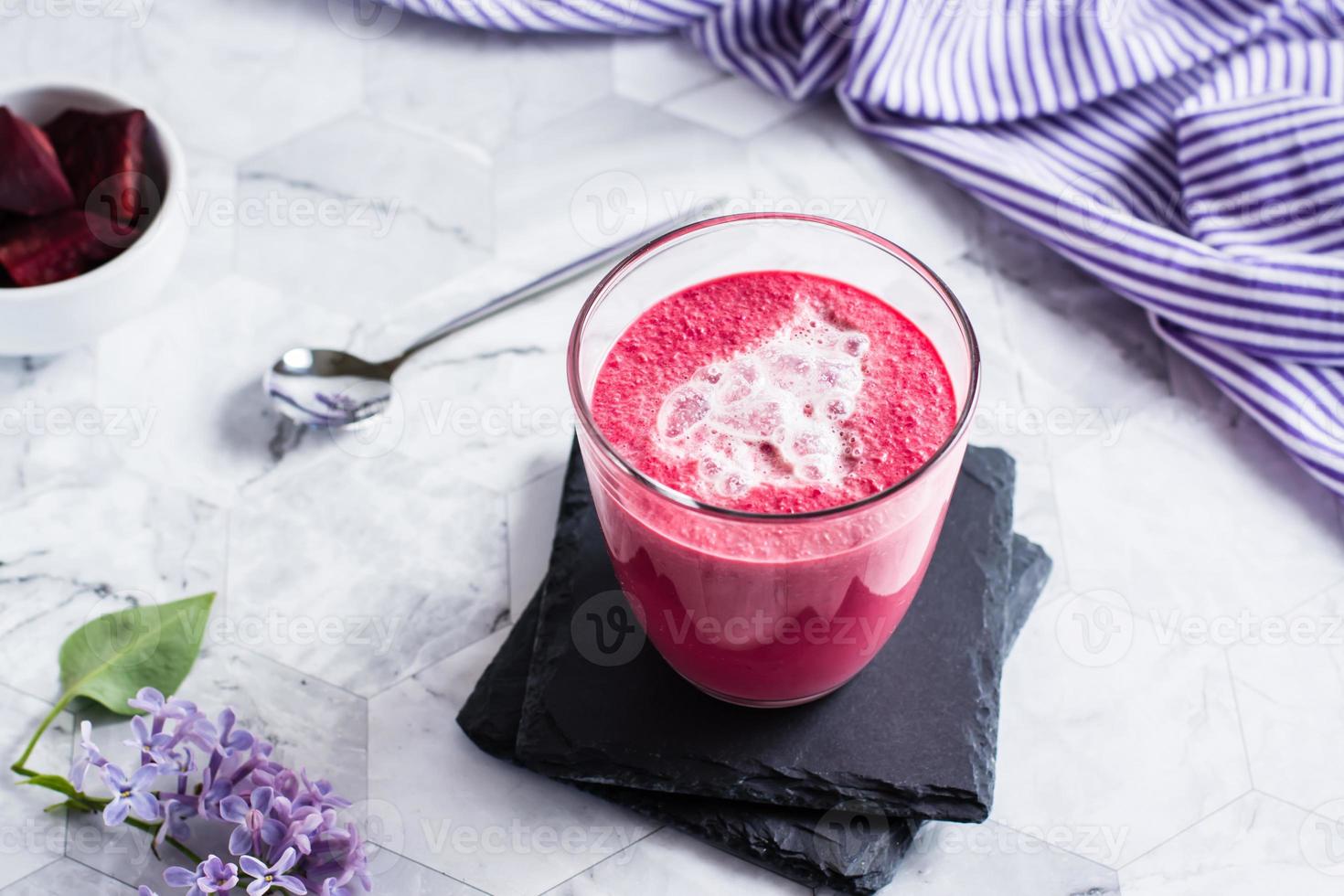 latte de betteraves sucrées avec mousse de lait dans un verre sur la table. boissons vitaminées maison saines photo