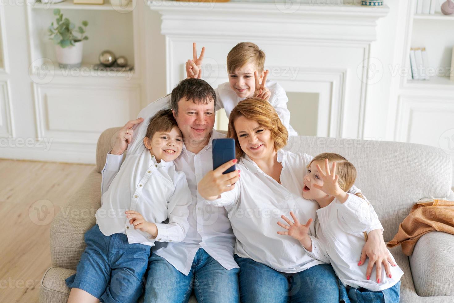 Portrait de famille gaie caucasienne parents heureux et petits enfants prenant photo