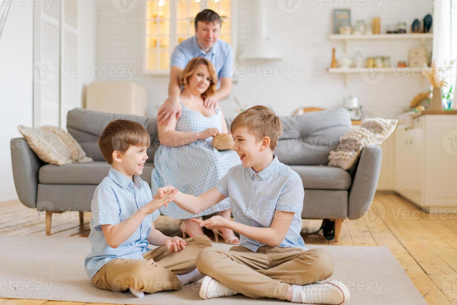 une famille heureuse passe du temps libre dans le salon, les jeunes parents se détendent sur un canapé photo