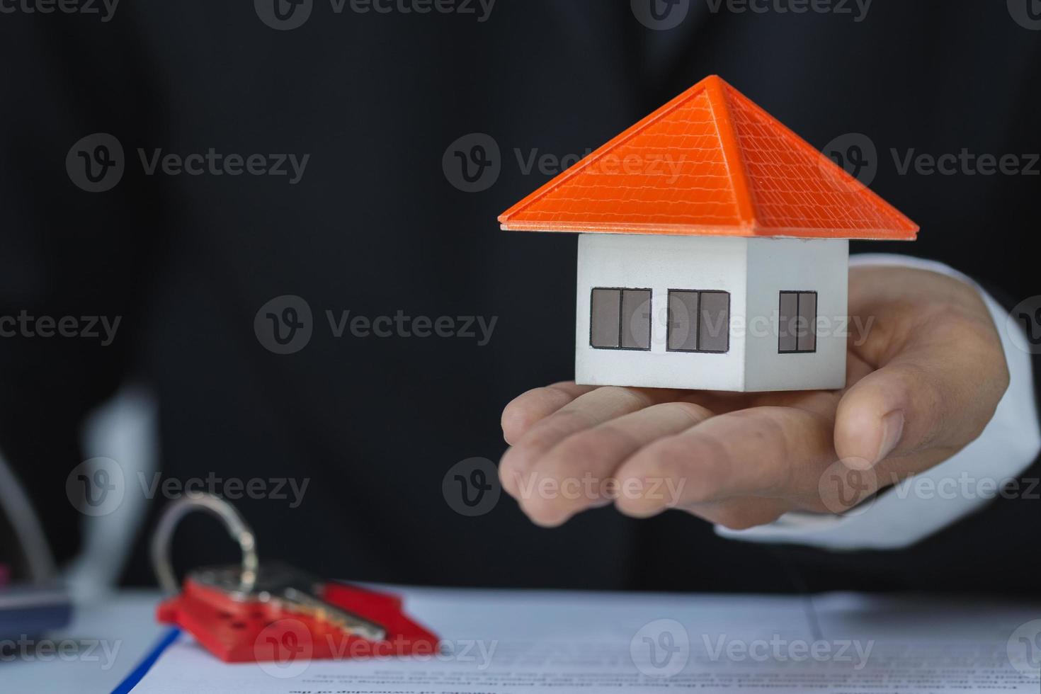 les investisseurs immobiliers tiennent des modèles de maison entre les mains. plan d'épargne pour acheter propriété, maison. concept financier personnel pour posséder une maison. pile de pièces sur table en bois. espace de copie. photo