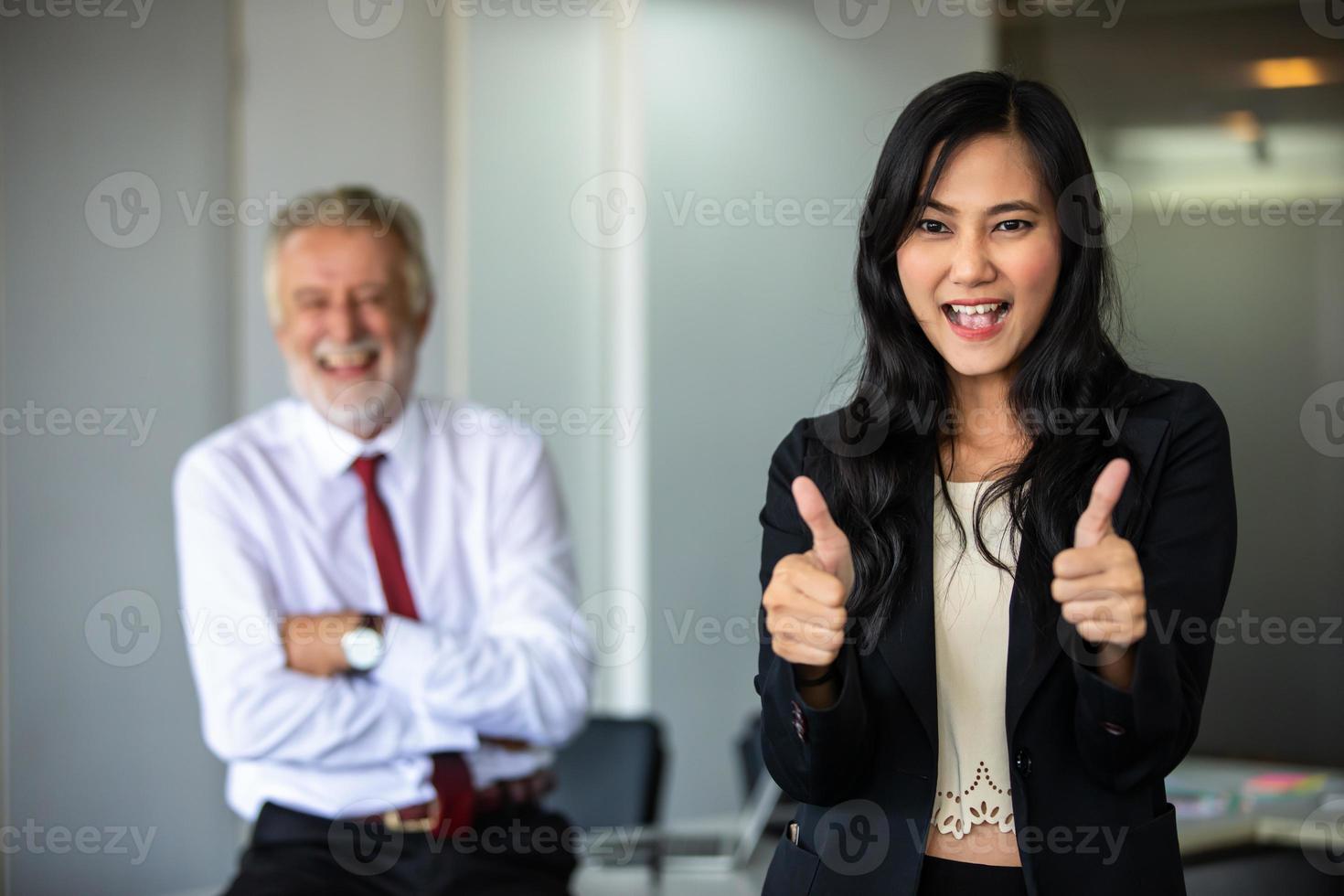 femme d'affaires lève le pouce et se tient souriant avec confiance et riant heureux dans la salle de conférence. photo
