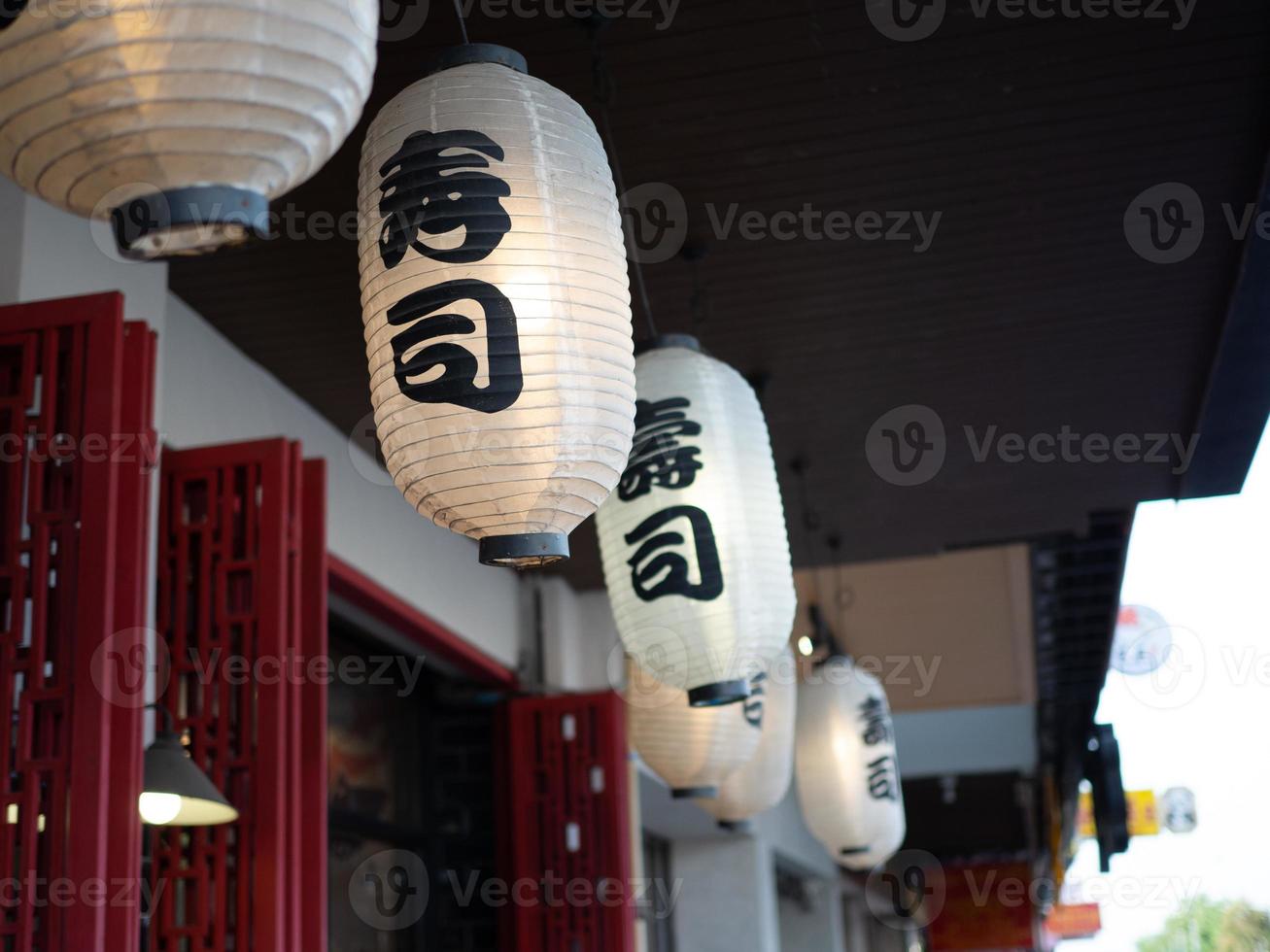 lanterne japonaise accrochée devant le restaurant japonais, le texte japonais sur la lanterne est la nourriture japonaise de sushi. photo