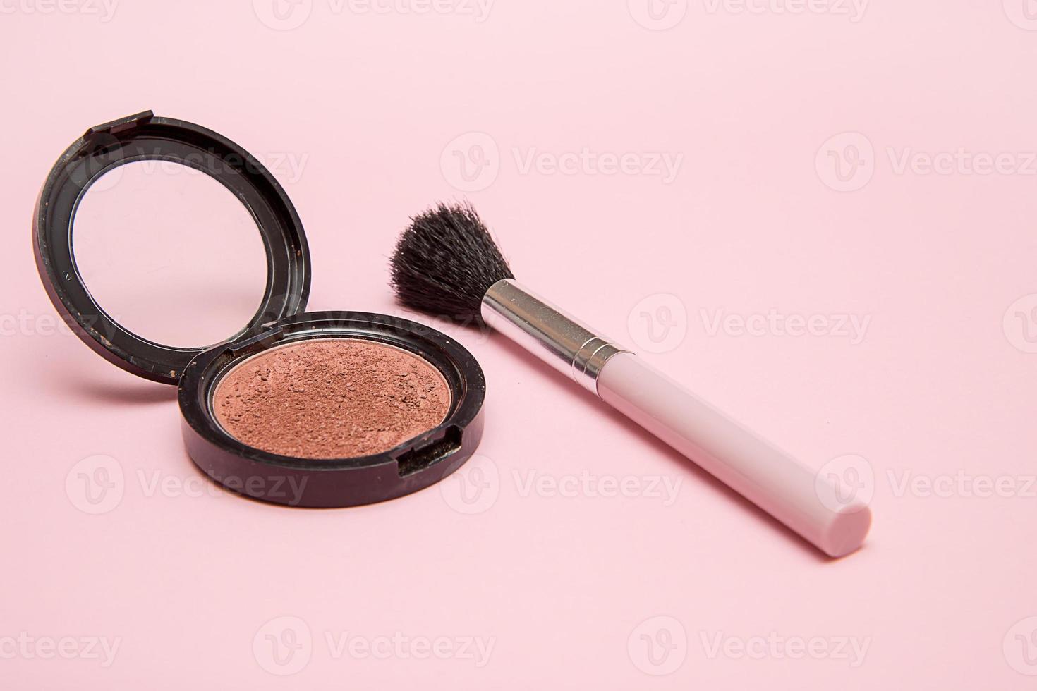fard à joues et pinceau de maquillage sur fond rose photo