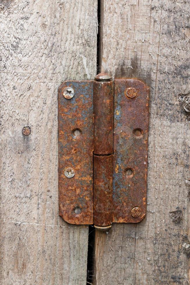 charnière de porte en métal rouillé. charnière de porte sur un mur en bois. photo