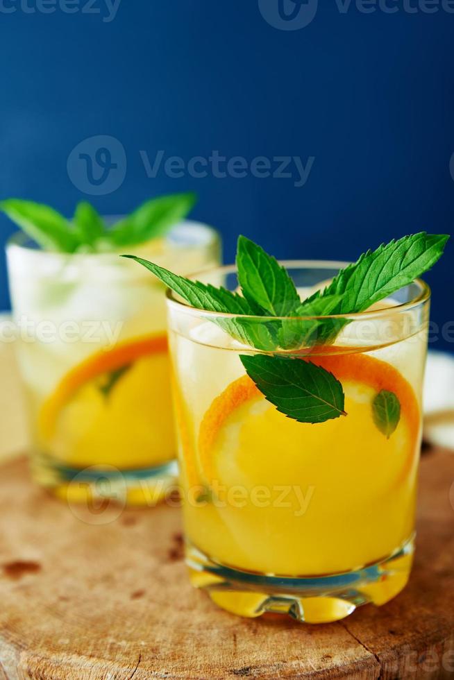 Limonade fraîche orange en verre sur fond sombre photo