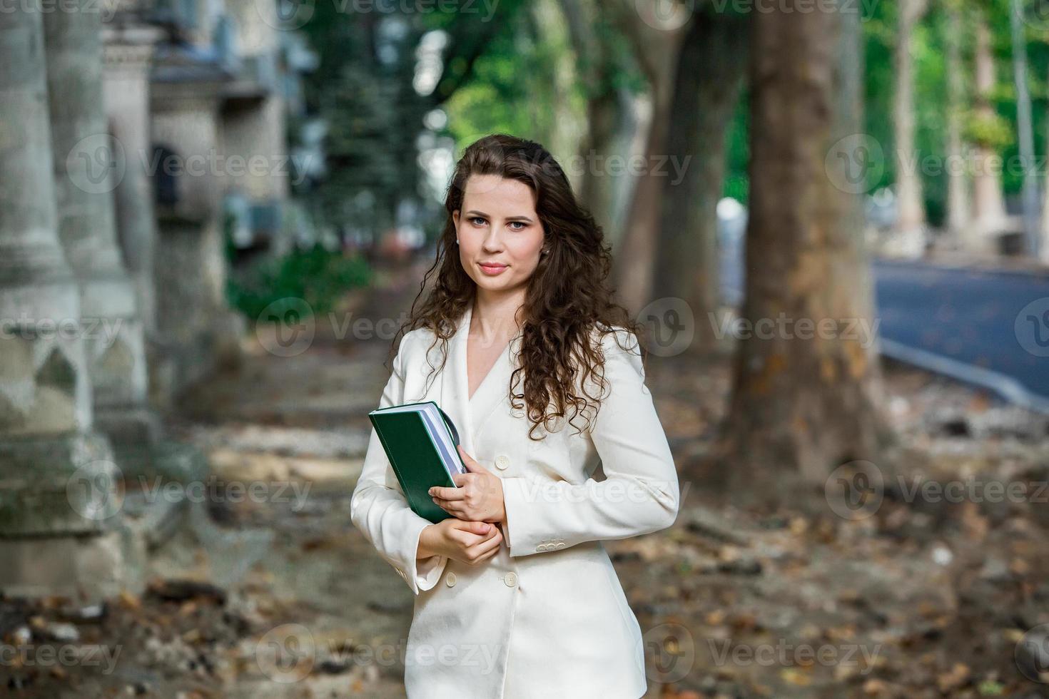 le portrait d'une femme d'affaires avec un cahier à la main. fille élégamment habillée à l'extérieur. femme européenne blanche réussie photo