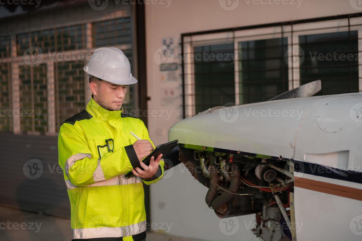 technicien fixant le moteur de l'avion, génie aérospatial masculin vérifiant les moteurs d'avion, maintenance mécanique asiatique inspecte le moteur d'avion photo