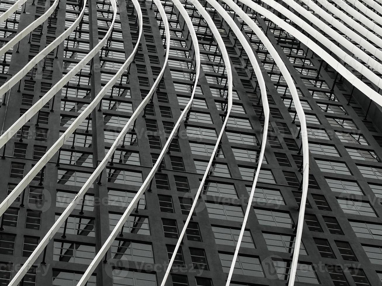 un motif en acier blanc et incurvé s'aligne sur un extérieur de bâtiment noir photo