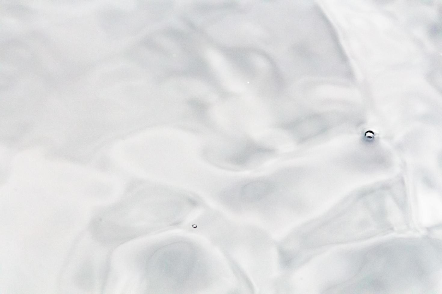 des gouttelettes d'eau ou des perles d'eau tombent à la surface de l'eau, provoquant la dispersion et la mousse de la surface de l'eau. photo