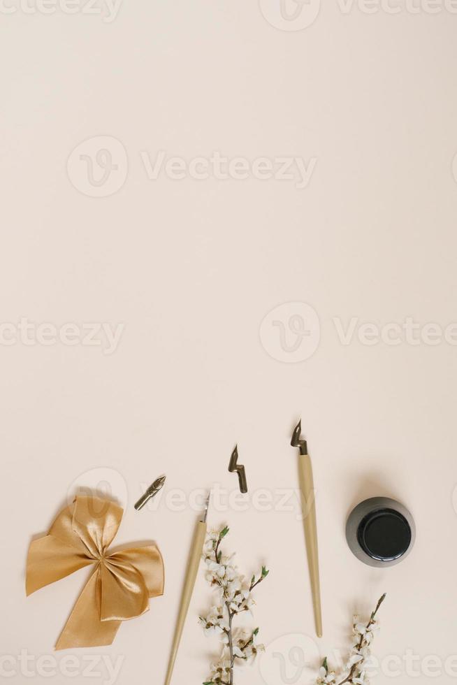 calligraphie, stylo pointu, encre, piquants, fleur de pommier, arc sur fond beige avec espace de copie photo