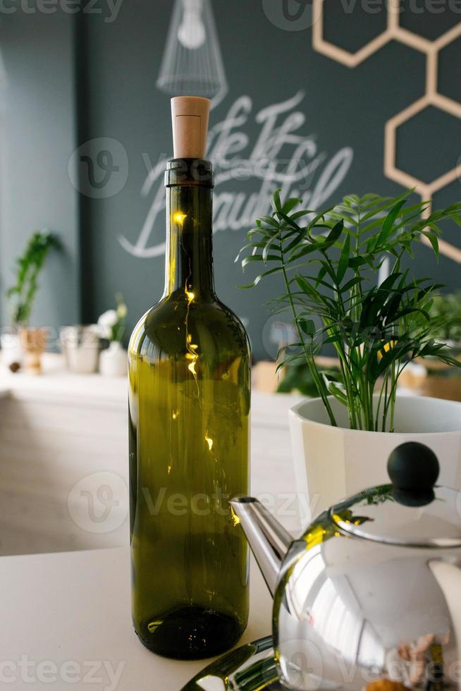 bouteille de vin vert en verre avec des lumières led dans le décor de la cuisine ou de la salle à manger photo