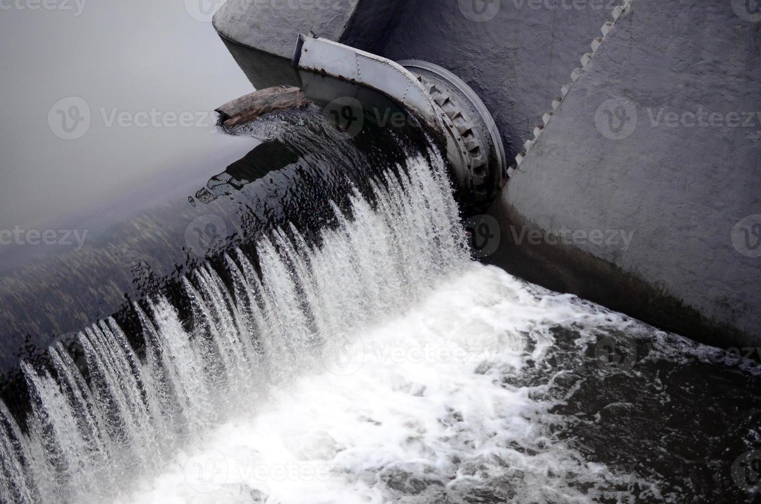 une image de l'eau qui coule. le barrage est conçu pour réguler le niveau d'eau dans les rivières de la ville et pour fournir de l'eau technique aux objets industriels photo