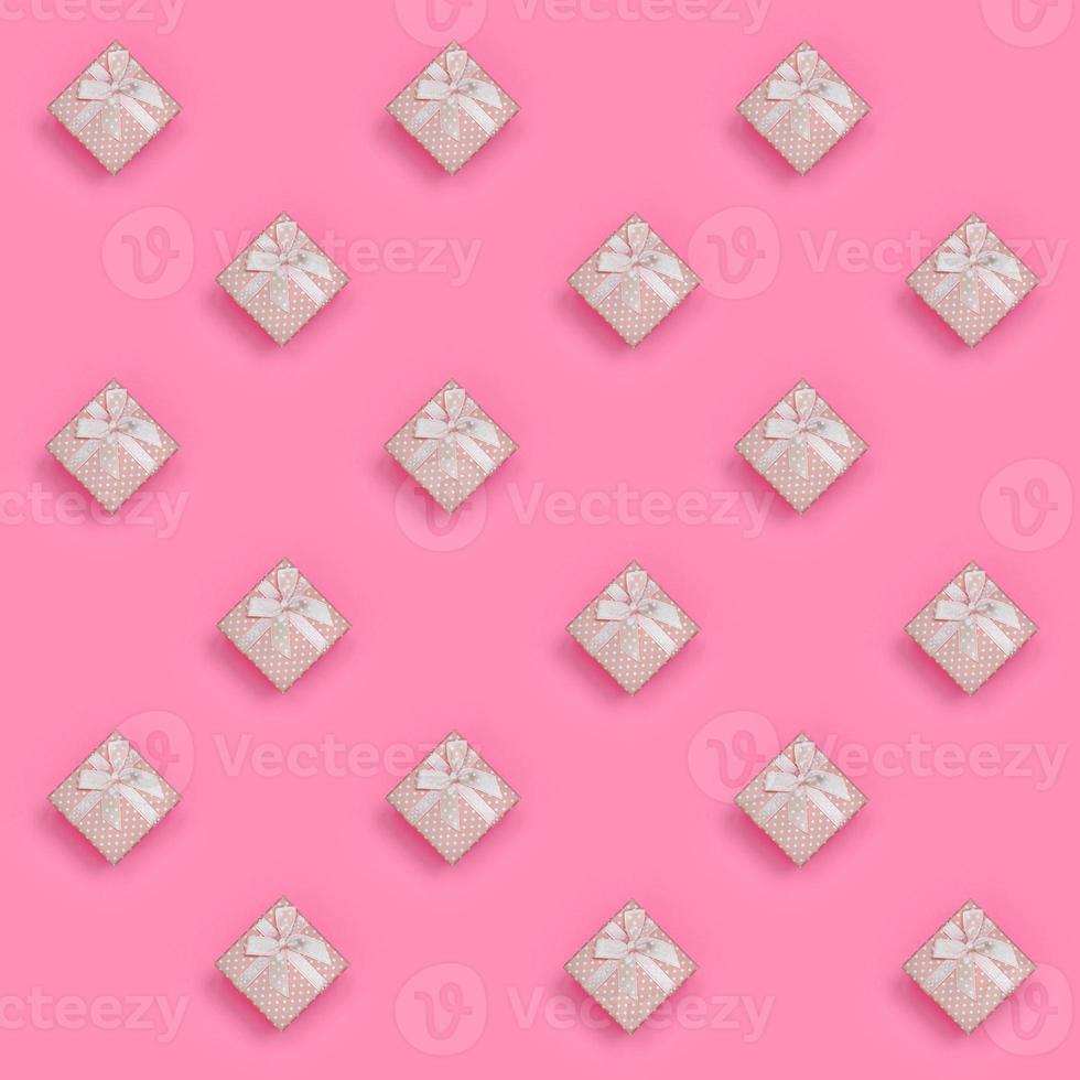 beaucoup de coffrets cadeaux roses se trouvent sur un fond de texture de papier de couleur rose pastel de mode dans un concept minimal. motif tendance abstrait photo