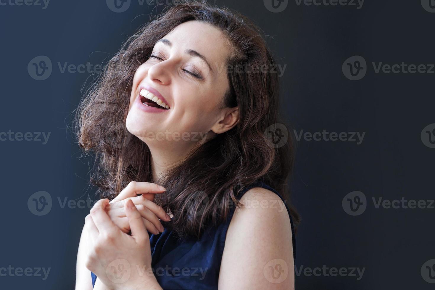fille heureuse souriante. portrait de beauté jeune femme brune riante positive heureuse sur fond noir isolé. femme européenne. émotion humaine positive expression faciale langage corporel photo