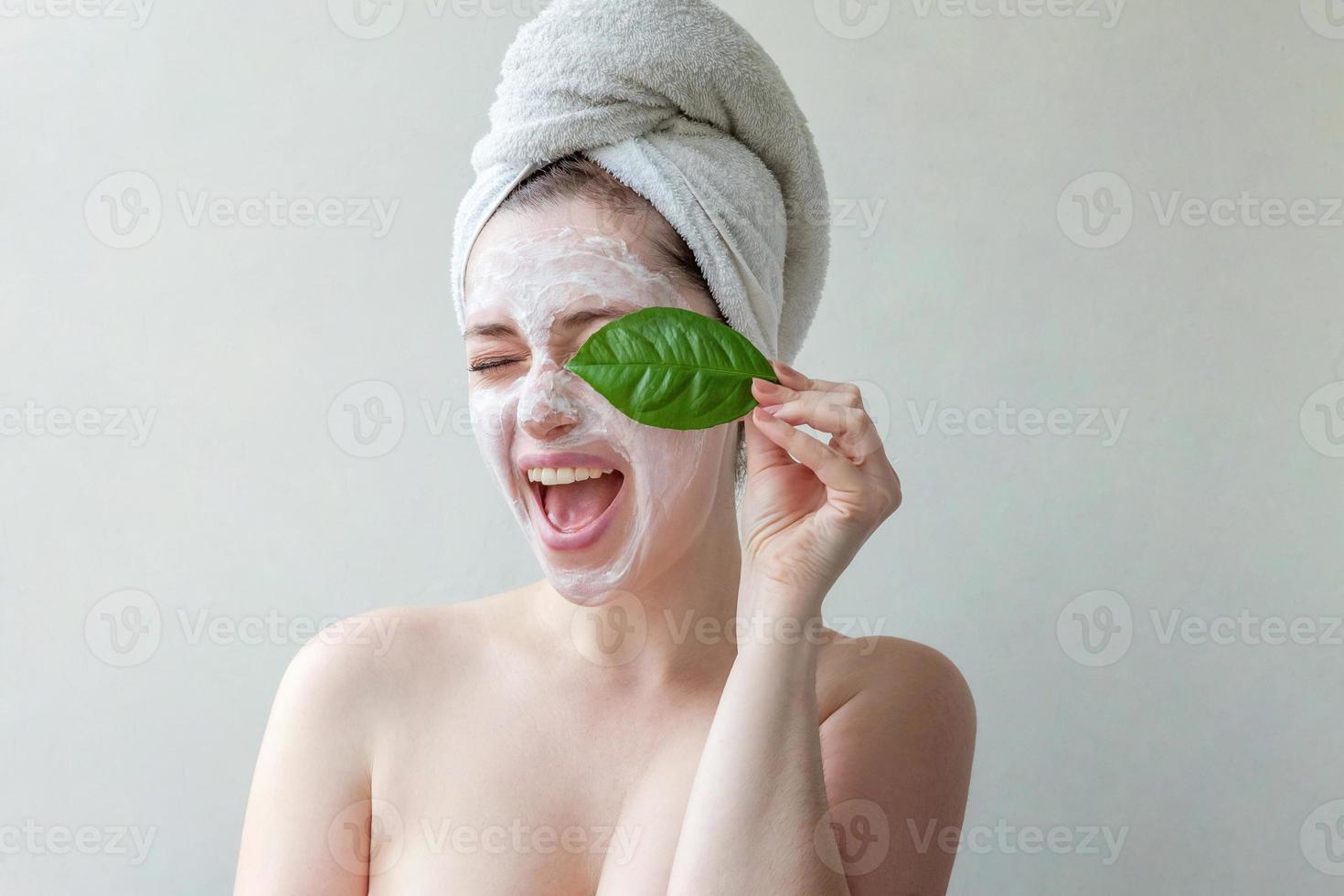 visage de femme avec feuille verte et crème ou masque nourrissant photo