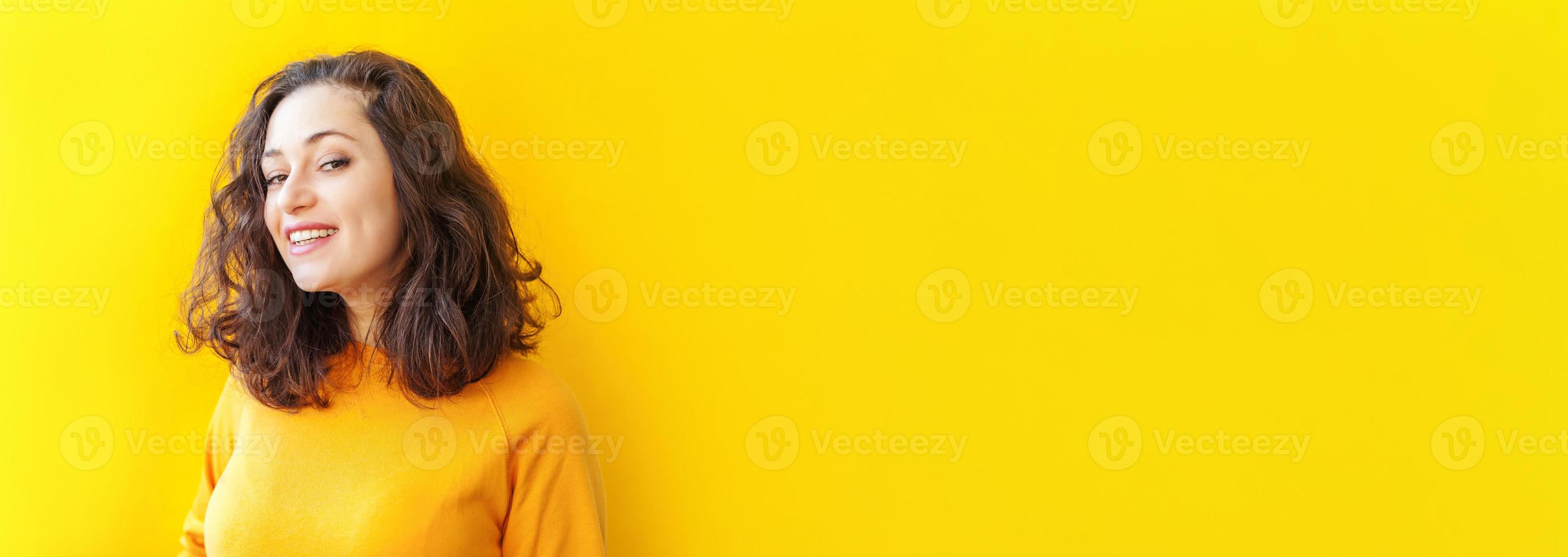 fille heureuse souriante. portrait de beauté jeune femme brune riante positive heureuse sur fond jaune isolé. femme européenne. émotion humaine positive expression faciale bannière de langage corporel photo