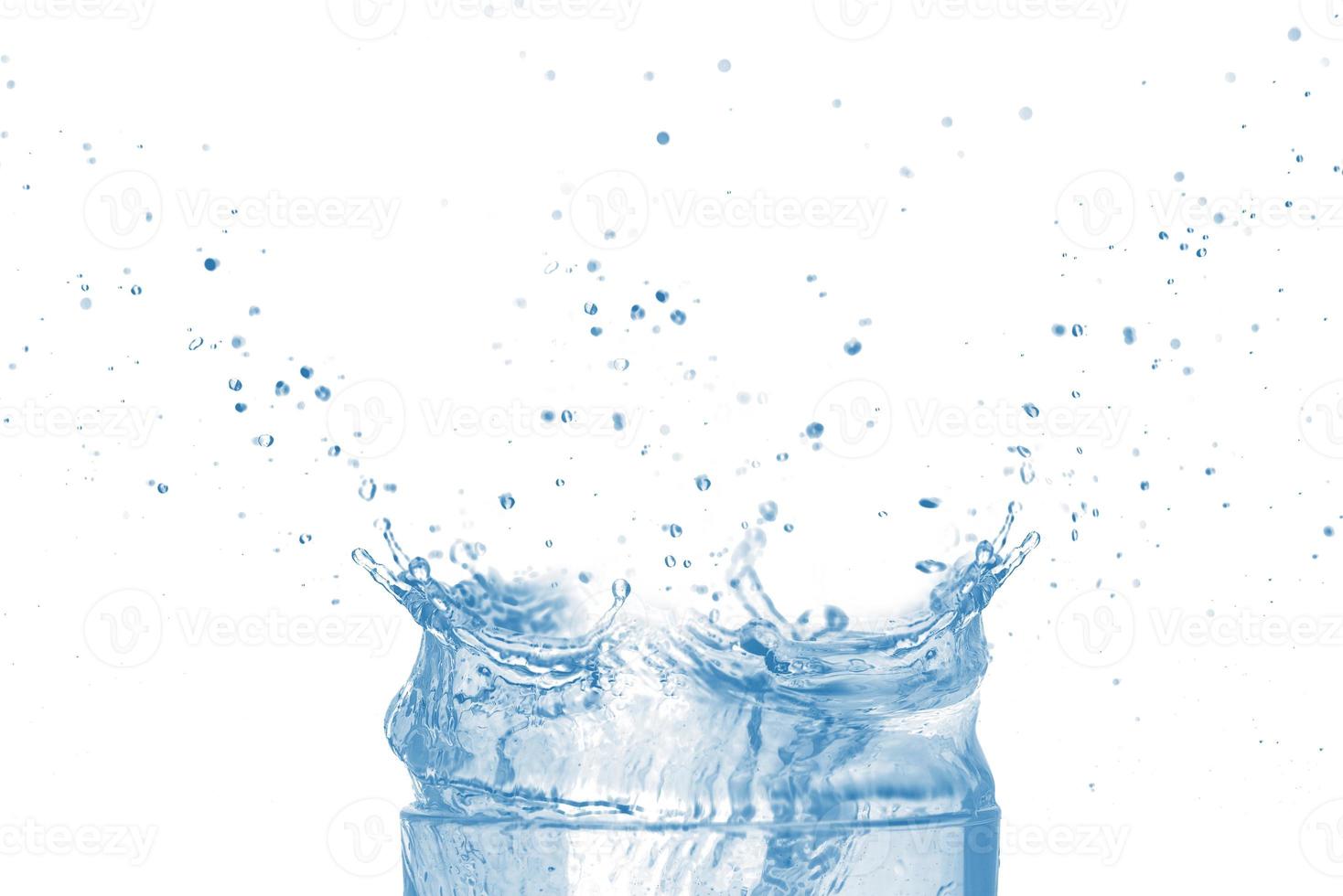 dessus du verre transparent et des éclaboussures d'eau bleue isolées sur fond blanc. photo