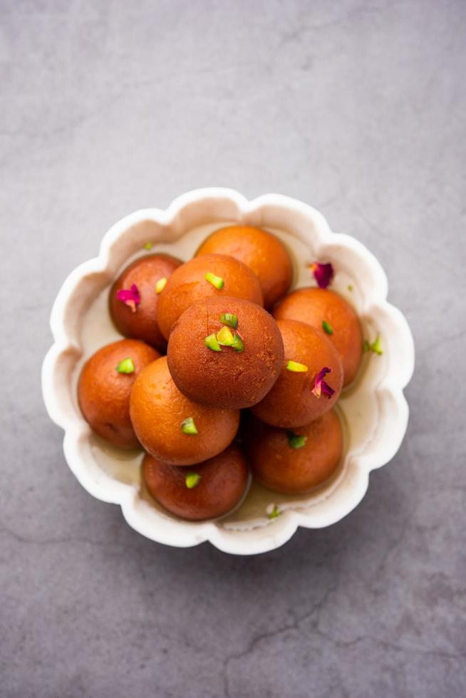 gulab jamun ou gulabjamun est un bonbon indien, servi dans un bol en tas. vue rapprochée photo