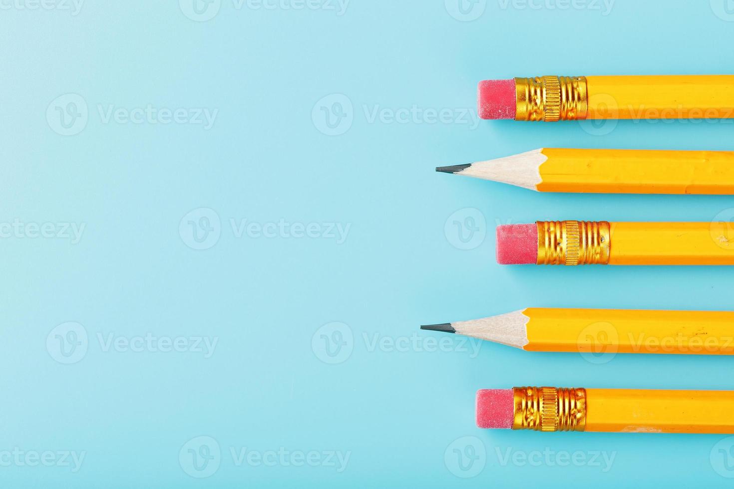 crayons orange avec une gomme sur fond bleu. photo