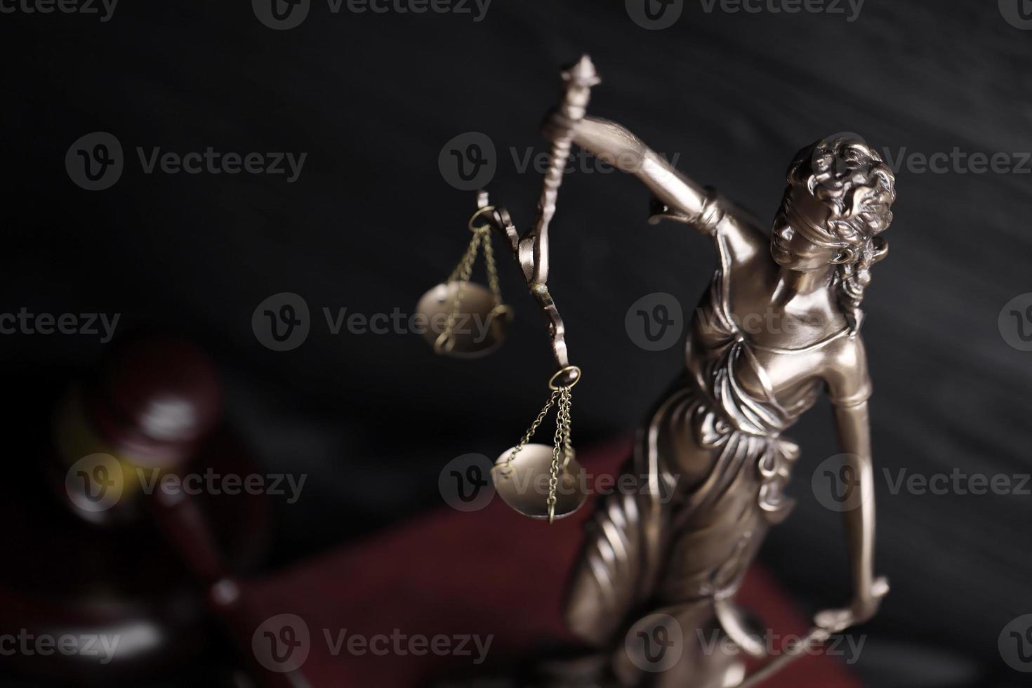 la statue de la justice - dame justice ou justitia la déesse romaine de la justice. statue sur livre brun avec marteau de juge. concept de procès judiciaire, de procédure judiciaire et de travail des avocats photo