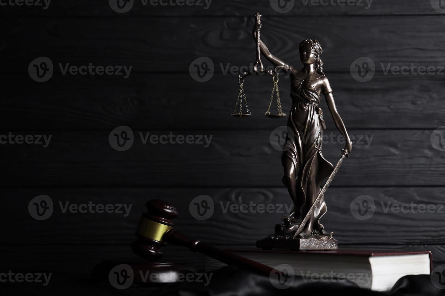 la statue de la justice - dame justice ou justitia la déesse romaine de la justice. statue sur livre brun avec marteau de juge. concept de procès judiciaire, de procédure judiciaire et de travail des avocats photo