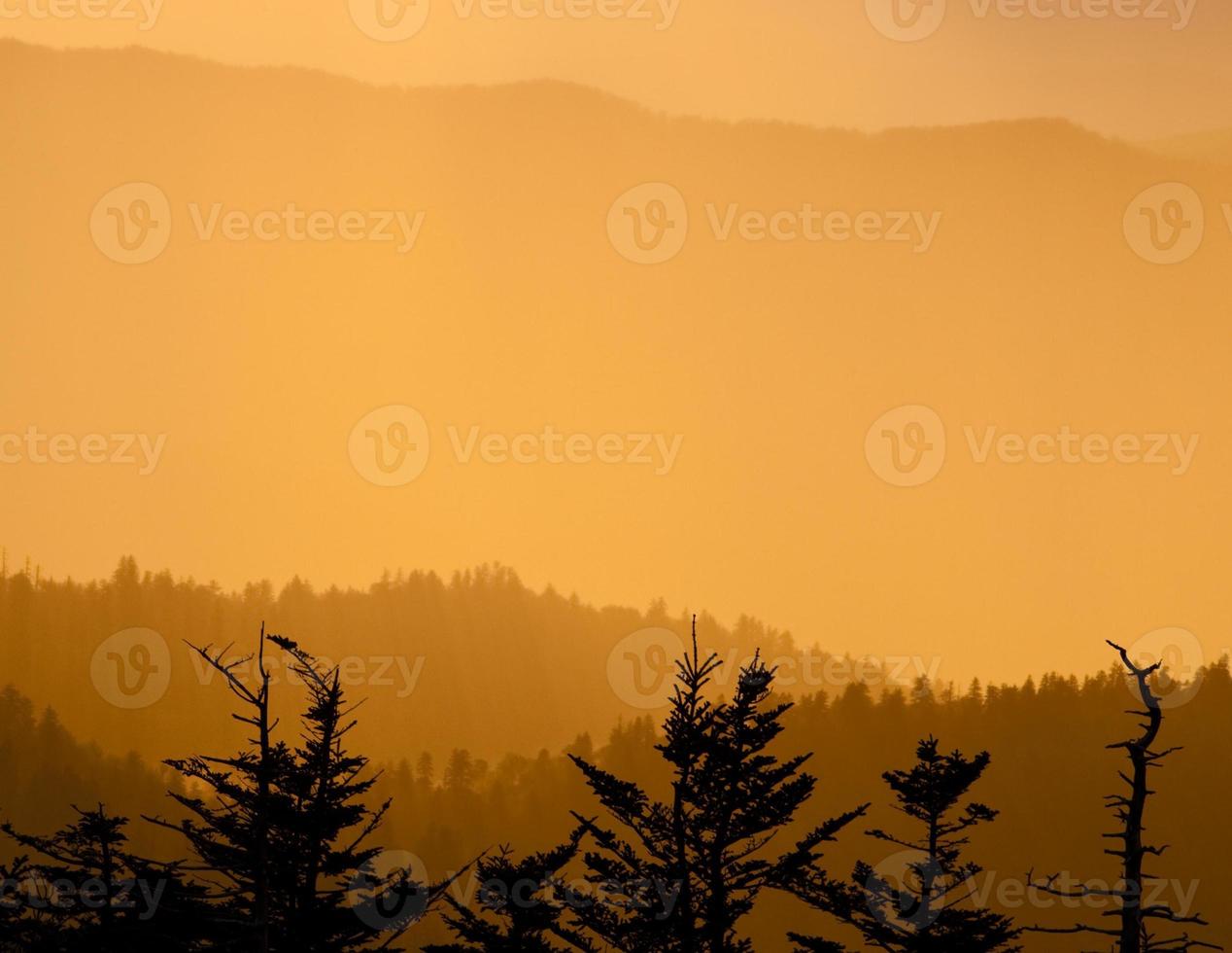 crêtes de montagnes enfumées au coucher du soleil photo