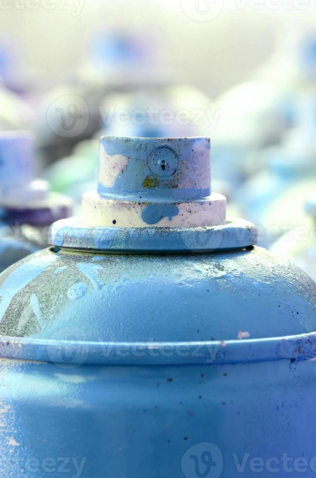 beaucoup de bombes aérosols sales et usagées de peinture bleu vif. photographie macro avec une faible profondeur de champ. mise au point sélective sur la buse de pulvérisation photo