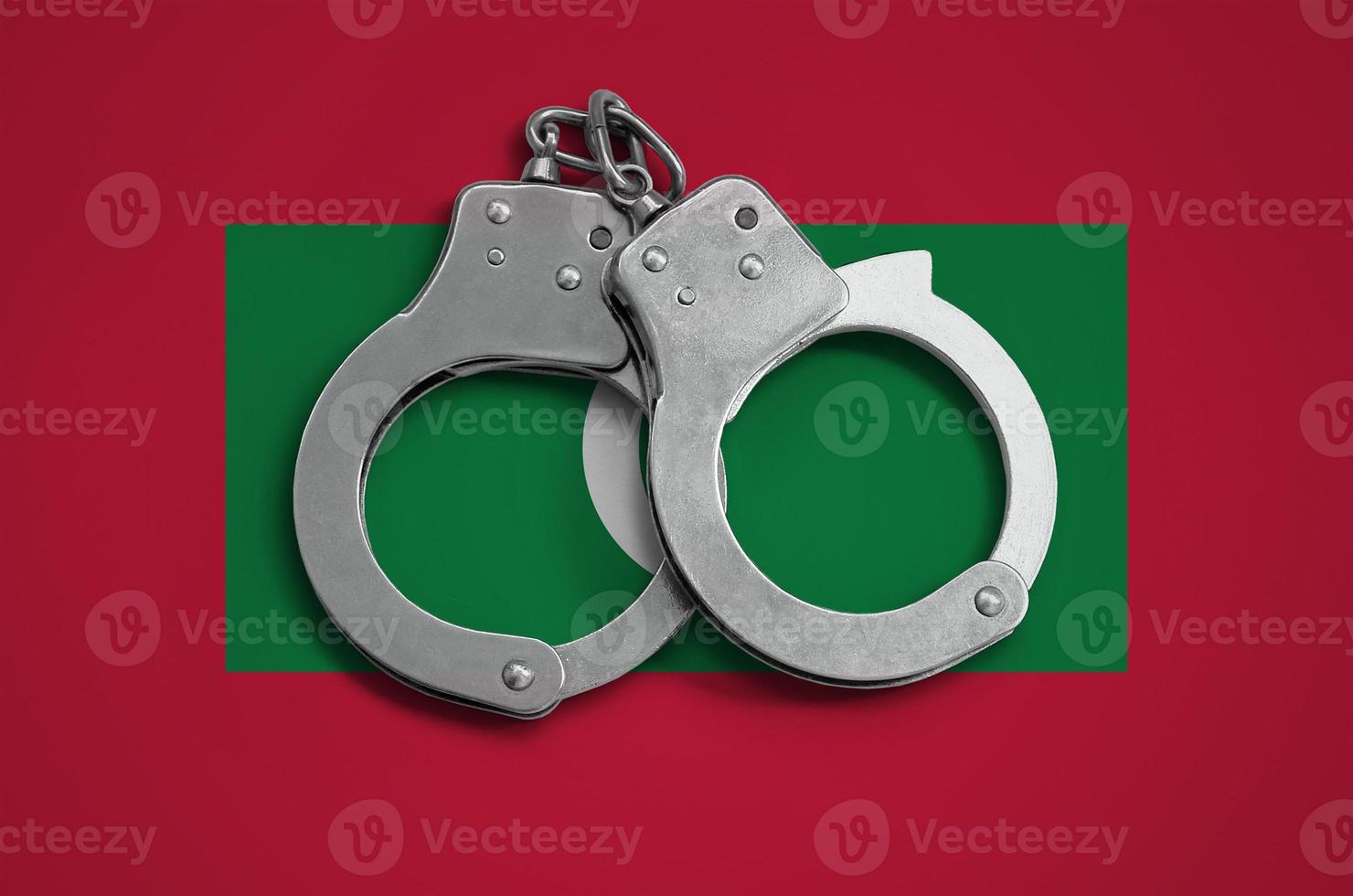 drapeau des maldives et menottes de police. le concept de respect de la loi dans le pays et de protection contre le crime photo