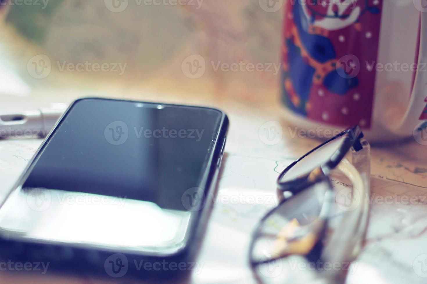 carte, carte de l'état de washington, stylo, lunettes, téléphone portable, tasse à café sur la table. photo