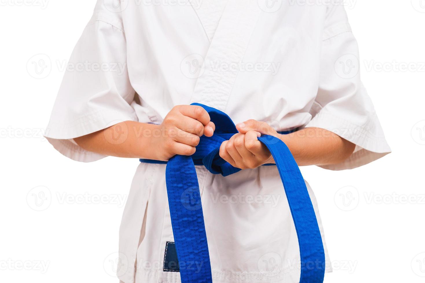 ceinture bleue. petit garçon en kimono faisant le noeud de sa ceinture noire photo