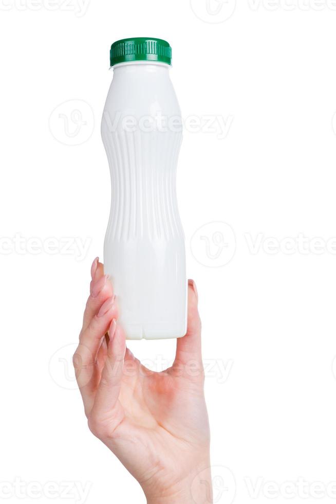 boisson vivifiante. image recadrée d'une jeune femme tenant une bouteille blanche avec du lait en se tenant debout sur fond blanc photo