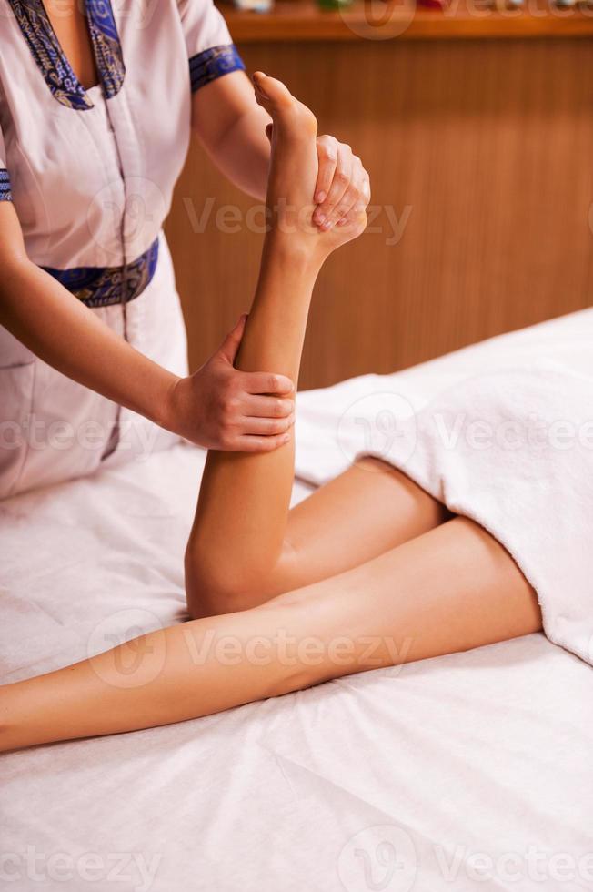 masser les jambes. vue de dessus du massothérapeute massant la belle jambe féminine photo