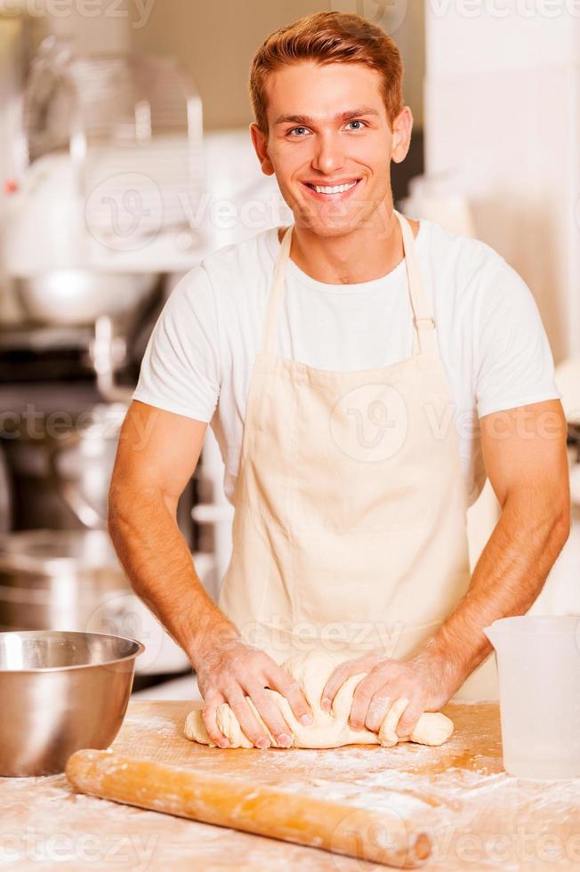 boulanger pétrir la pâte. image recadrée d'un boulanger mâle pétrissant la pâte photo