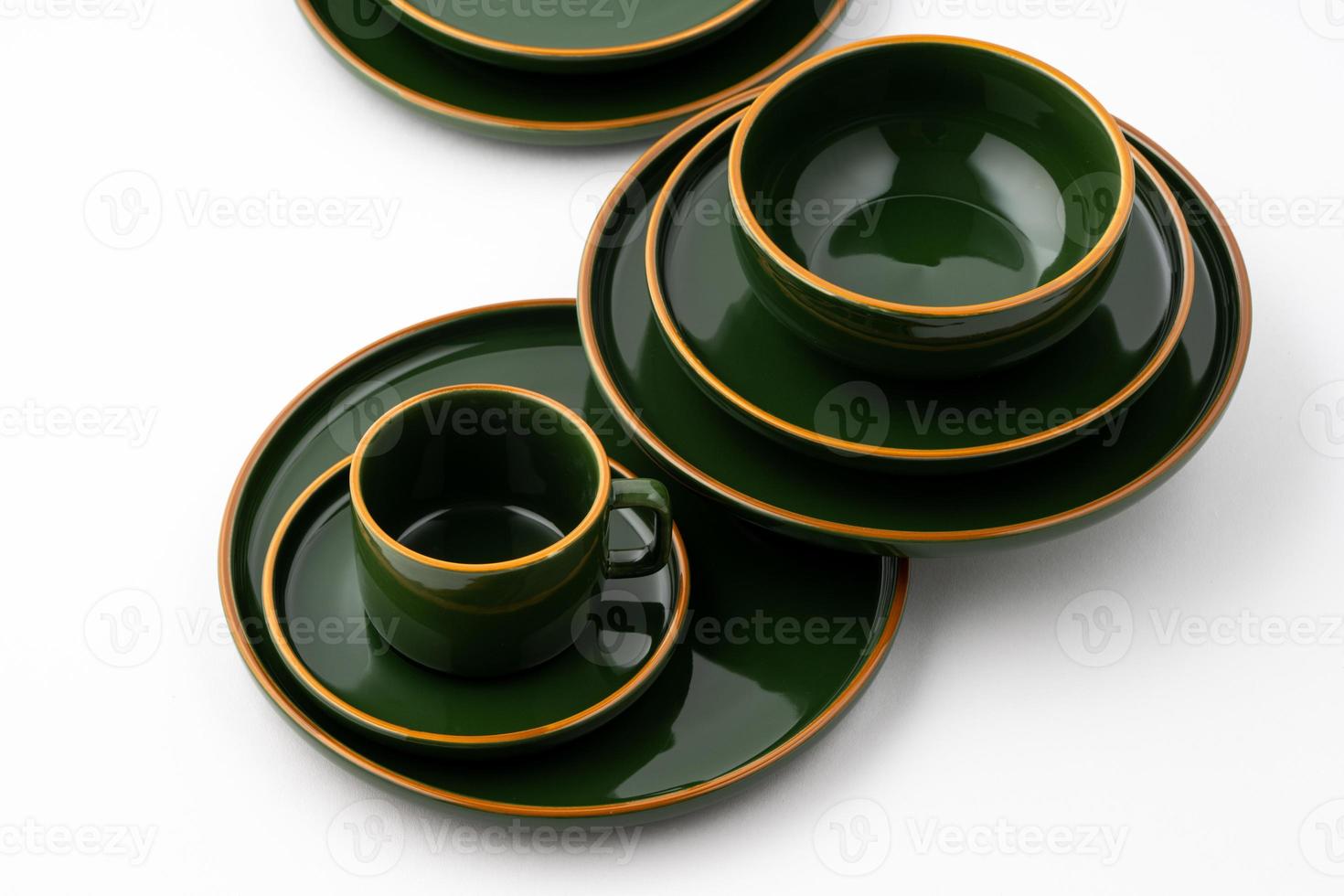 un ensemble de vaisselle en céramique vert foncé avec des contours orange photo