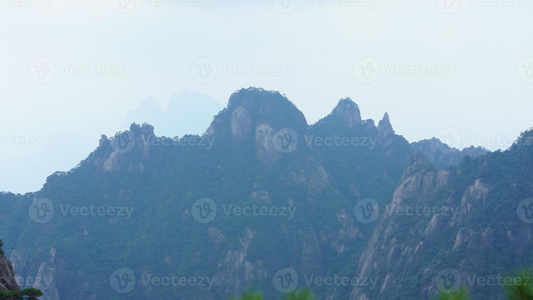 les beaux paysages de montagnes avec la forêt verte et la falaise rocheuse en éruption en arrière-plan dans la campagne de la chine photo