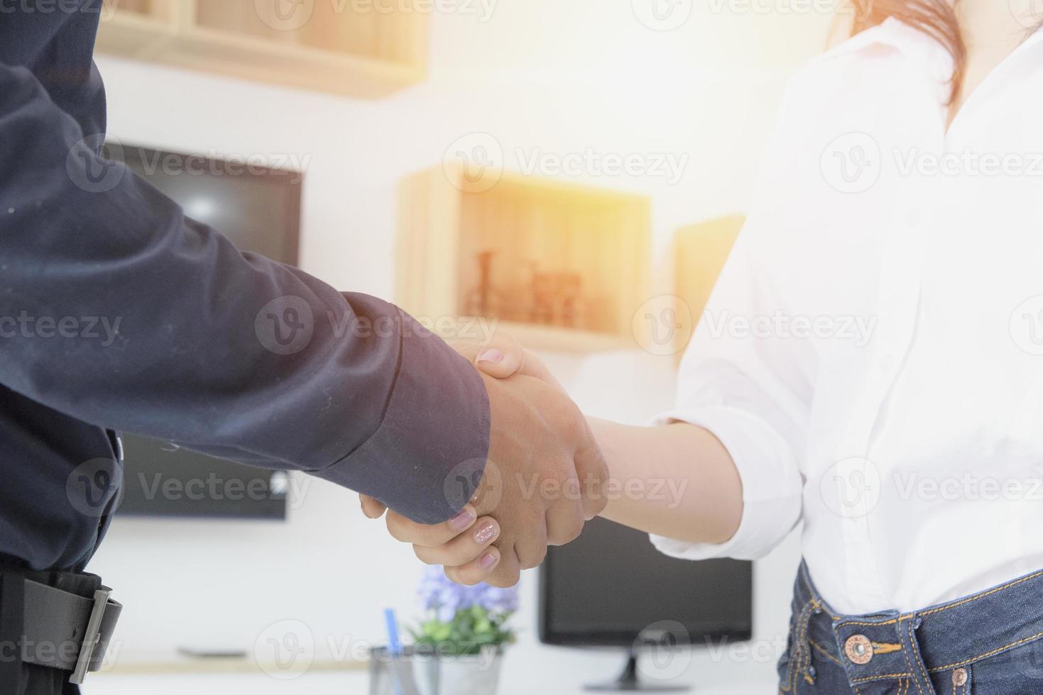 femme d'affaires se serrant la main à proximité du bureau, se présentant, saluant ou remerciant. photo