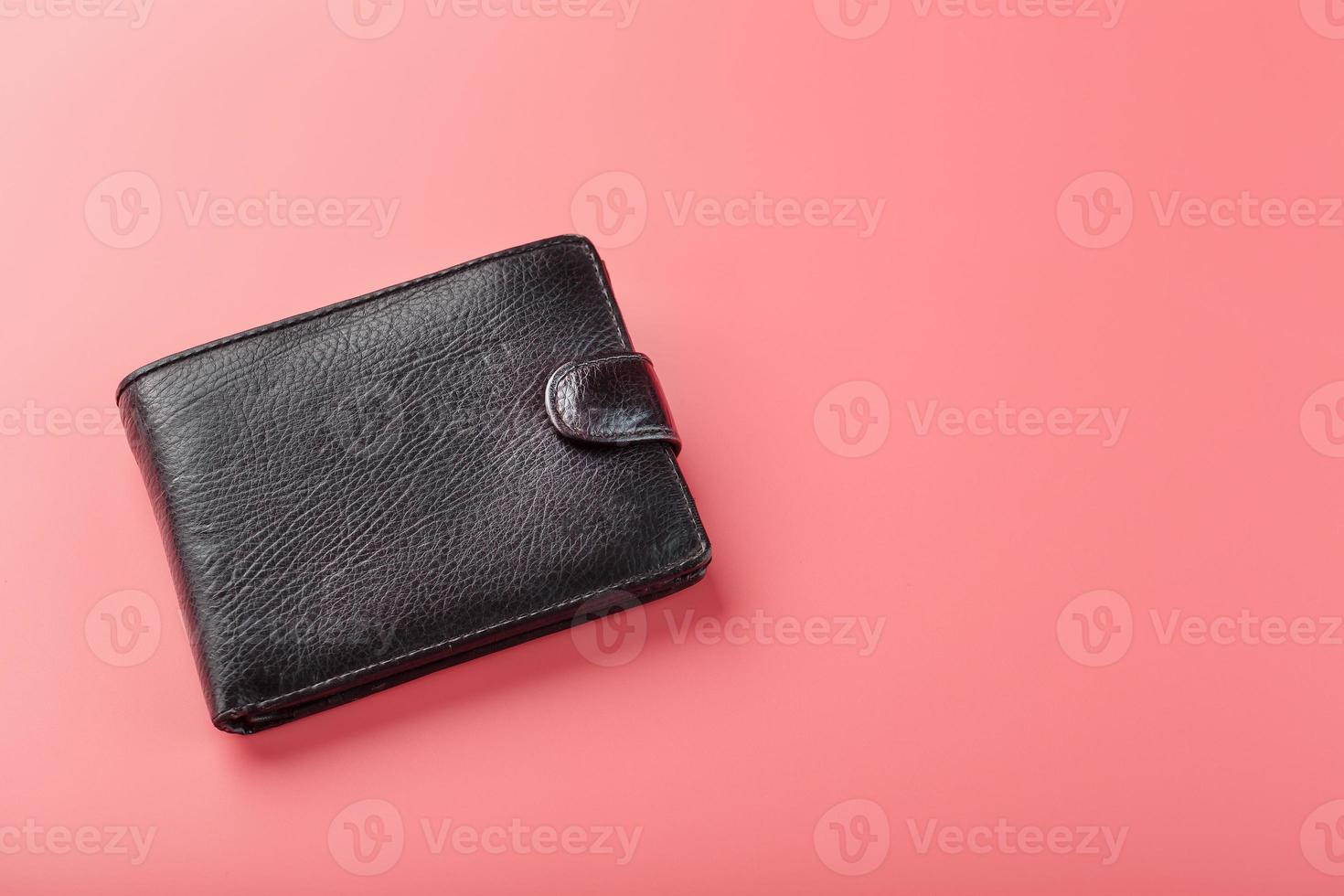 portefeuille noir sur fond rose. symbole de prospérité et de prospérité. photo